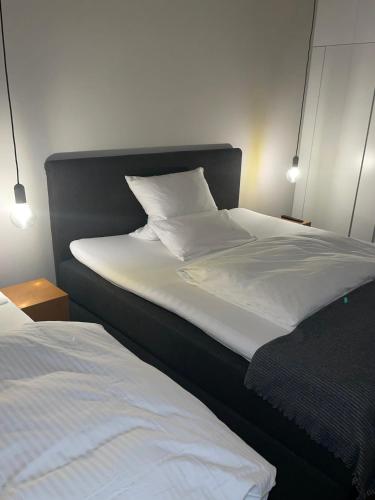 a bedroom with two beds with white sheets at Hotel Lindenhof in Erkelenz