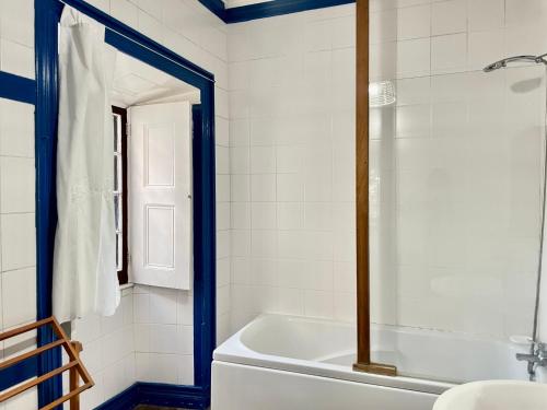uma casa de banho com uma banheira branca e um lavatório. em Casa Via d'Agua in Fajã Grande em Faja Grande