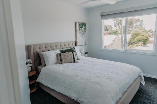 a bedroom with a large bed and a window at The Sage Cottage - Explore Bendigo CBD on foot! in Bendigo