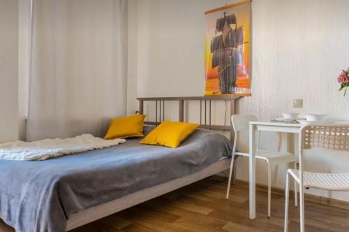 a bedroom with a bed with yellow pillows and a table at VIP apart 768 in Tbilisi City
