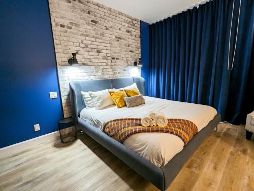 1 dormitorio con 1 cama con paredes azules y cortinas azules en LE LOFT BLEU - Centre-Ville de Québec, en Quebec