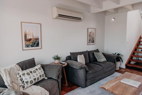 a living room with a couch and a fan at The Sage Cottage - Explore Bendigo CBD on foot! in Bendigo