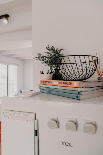 a stack of books on a counter with a potted plant at The Sage Cottage - Explore Bendigo CBD on foot! in Bendigo