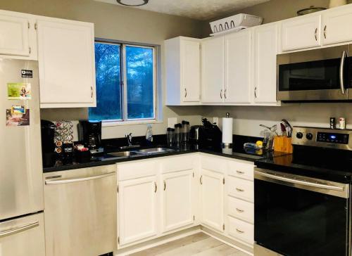 a kitchen with white cabinets and black appliances at Holly Oaks in Columbus