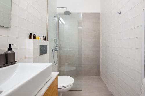 a white bathroom with a toilet and a shower at The Nook in Athens