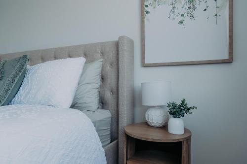 a bedroom with a bed and a table with a lamp at The Sage Cottage - Explore Bendigo CBD on foot! in Bendigo