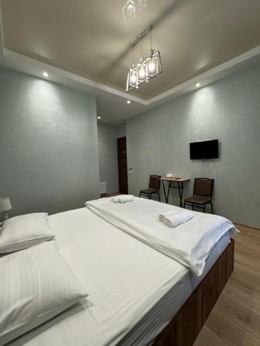 Un dormitorio con una cama grande y una mesa con sillas. en Veranda L&G en Kutaisi