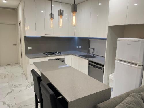 a kitchen with white cabinets and a counter top at Guest House - Self Contained in Villawood
