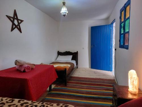 a room with two beds and a blue door at Asala Guest House in Taghazout