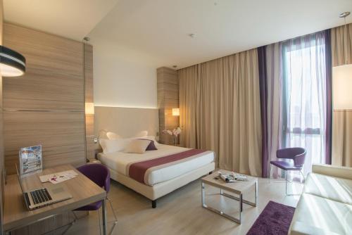 a hotel room with a bed and a desk and a room at AS Hotel Limbiate Fiera in Limbiate