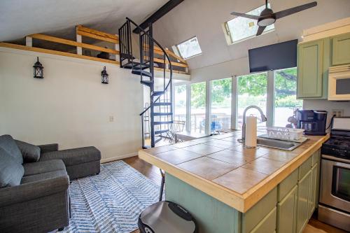 cocina y sala de estar con sofá y barra de cocina en Little Chi Cottages, en Noblesville