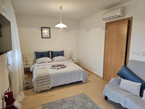 a bedroom with a large bed and a chair at Apartman Šimun in Varaždin