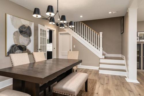 a dining room with a table and chairs and a staircase at Riverside Retreat! in West Lafayette