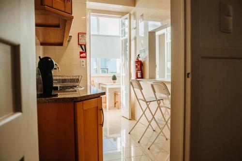 a kitchen with a counter and some chairs in it at Belém Tejo - Jardim by Local in Lisbon