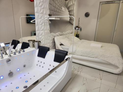 a bathroom with a tub and a bed in it at WARSZAWA CENTRAL HOUSE - Studios in Warsaw with Private Jacuzzi, full access to Sauna, Gym and Billards - Studia z prywatnym Jacuzzi oraz dostępem do sauny, siłowni i bilarda in Warsaw