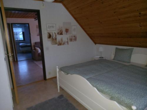 sypialnia z łóżkiem i drewnianym sufitem w obiekcie Smålandshus w mieście Målilla