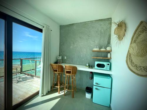 a kitchen with a counter and two bar stools at 1 Corcega Beachfront Suites in Rincon