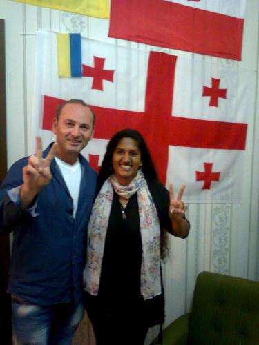a man and a woman standing in front of a flag at Giorgi's Homestay in Kutaisi