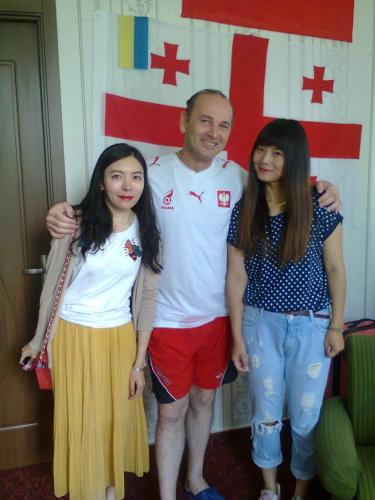 a man and two girls standing in front of a flag at Giorgi's Homestay in Kutaisi