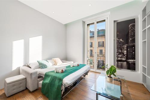 a white living room with a couch and a glass table at Idromassaggio Brera - 5 min Duomo in Milan