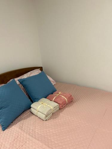 a bed with three pillows on top of it at Domaćinstvo Marić in Ivanjica