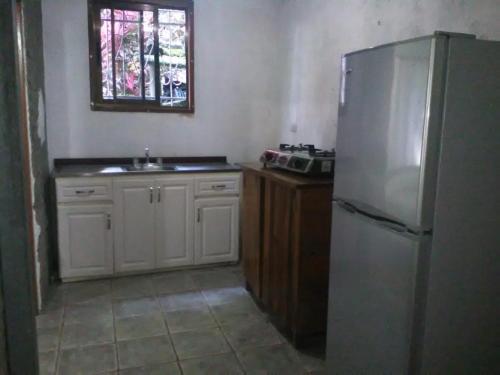 uma cozinha com um frigorífico, um lavatório e uma janela em Casa Susen em Montezuma