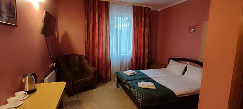 a hotel room with a bed and a chair at Лелеч in Tatariv