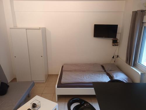 una piccola camera con letto e TV a parete di Palm Beach Apartment Peraia a Perea
