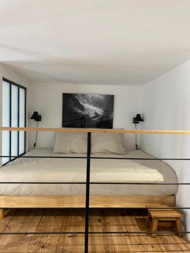 Ce lit se trouve dans un dortoir blanc doté de 2 lampes. dans l'établissement Athéna, à Caen