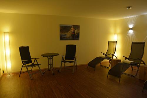 a room with chairs and a table and a painting at Boutique Hotel Wolfsburg in Wolfsburg