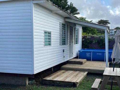 a white house with a porch and a deck at Small, Private Beach House & Pool in Vega Baja