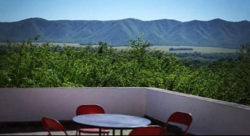 a table and chairs on a balcony with a view of mountains at Hostel Amarillo in San Ignacio