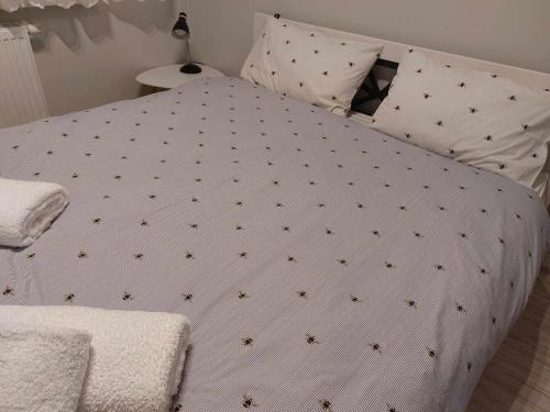 a bed with a white comforter with stars on it at Bee Happy Apartament Wrzesnia ll in Września