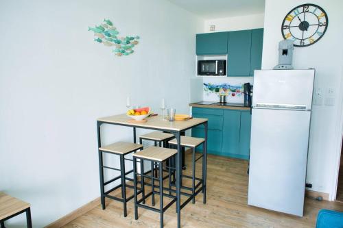una cucina con un piccolo tavolo e un frigorifero di Le Yachting vue mer a Le Barcarès
