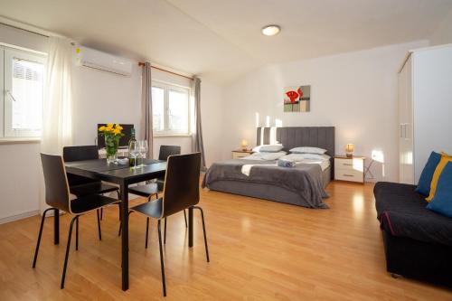 a bedroom with a bed and a table and chairs at Apartments Luka free bikes in Rovinj