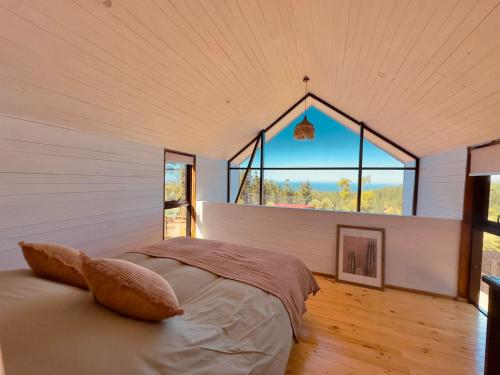 um quarto com uma cama num quarto com uma janela em Casas Antubureo em Cáhuil