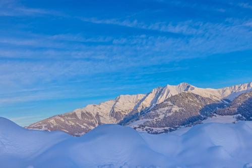a mountain covered in snow with a blue sky at Boutique Hotel Pellas in Vella