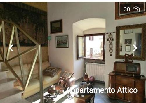 a living room with a staircase and a room with a mirror at CHARME in Civita Castellana