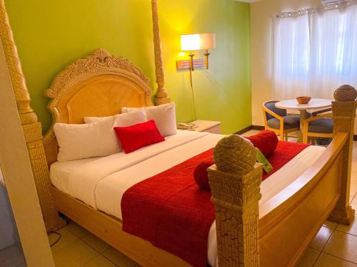 1 dormitorio con 1 cama grande con manta roja en Point Salines Hotel, en Gwa Kay