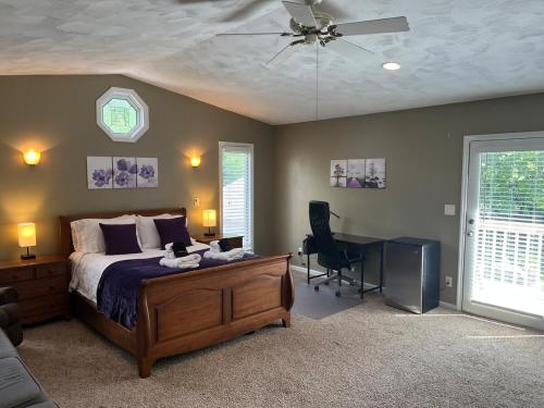 een slaapkamer met een bed, een bureau en een plafondventilator bij River's Rest in Columbus