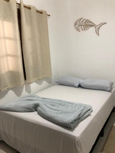 a bed with a blanket on it in a room at Pousada Beira-mar I in Bertioga