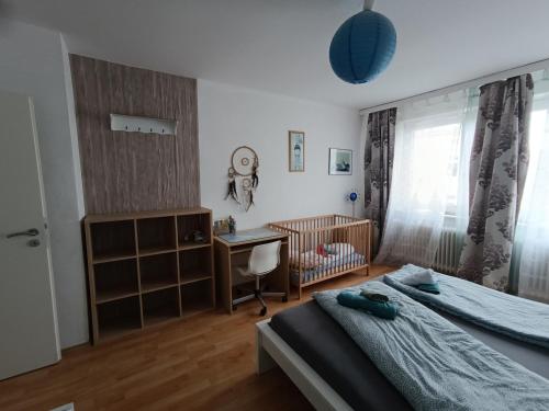 a bedroom with a bed and a crib and a desk at Ferienwohnung Maritim mit E-Bike Verleih in Wilhelmshaven