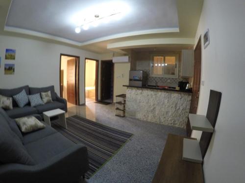Andalusia Resort - 2 Bedroom Apartment في الغردقة: غرفة معيشة مع أريكة ومطبخ
