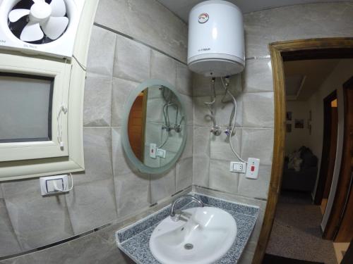 Andalusia Resort - 2 Bedroom Apartment في الغردقة: حمام مع حوض ومرآة
