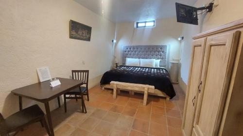 a bedroom with a bed and a table and a desk at Hotel 19 de Enero Centro in Bernal