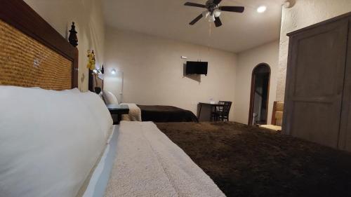 a bedroom with a bed and a ceiling fan at Hotel 19 de Enero Centro in Bernal