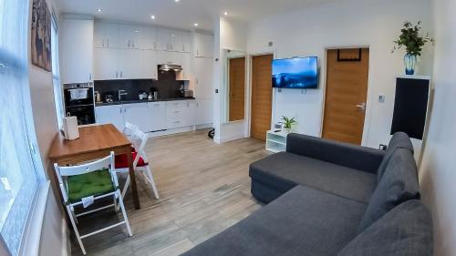 uma sala de estar com um sofá e uma cozinha em Beautiful 1 Bedroom Flat Close to City Centre em Londres
