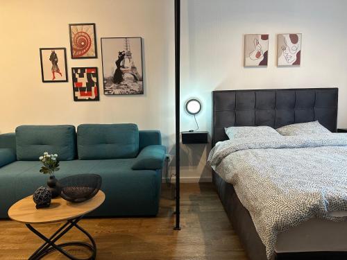 a bedroom with a bed and a blue couch at Sleep&Fly Belgrade in Ledine