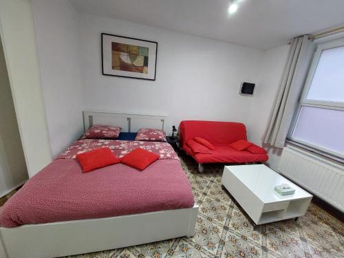 um quarto com uma cama vermelha e uma cadeira vermelha em Maison LYDIE - Meublé de vacances 3 étoiles em Charleroi