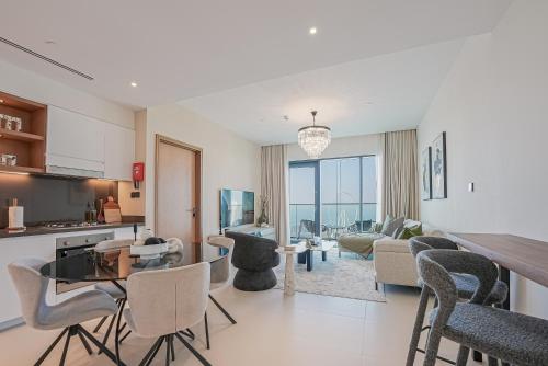 a kitchen and living room with chairs and a table at Modern 2BR High Floor Haven in Vida Dubai Marina in Dubai